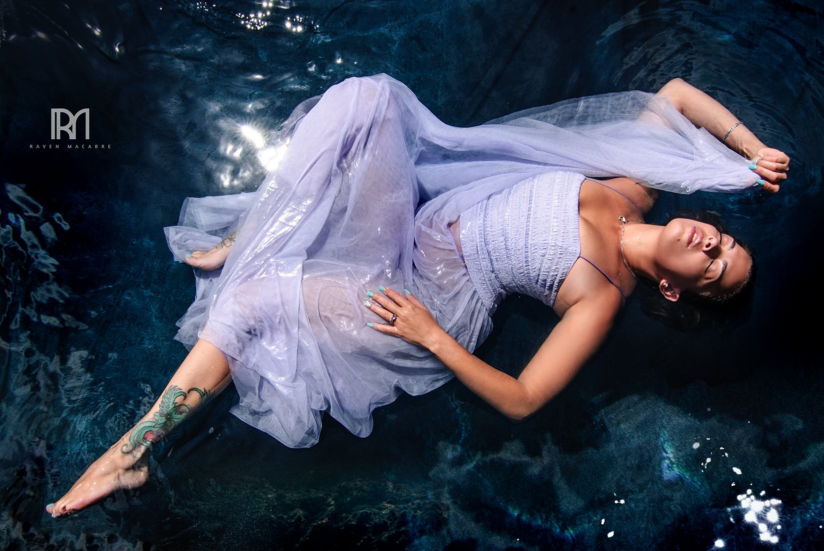 Woman in lavender fabric floating in dark water