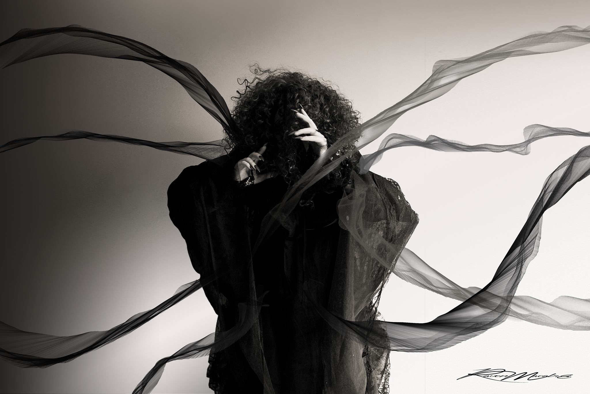 Black and white figure surrounded by flowing fabric